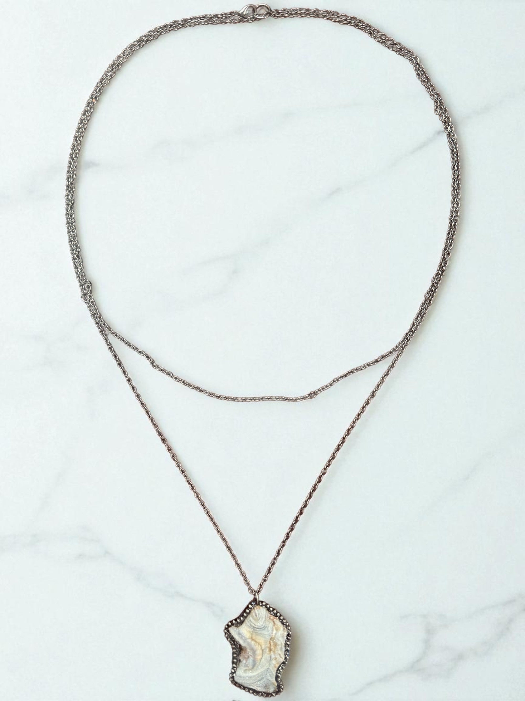 Necklace with a pendant on a marble surface